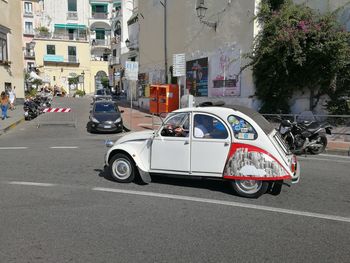 Cars on road by buildings in city