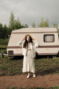 Portrait of woman standing against car