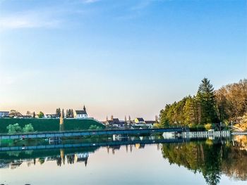Scenic view of river by buildings against sky