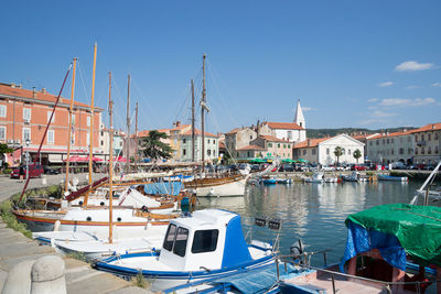 Boats moored at harbor in city