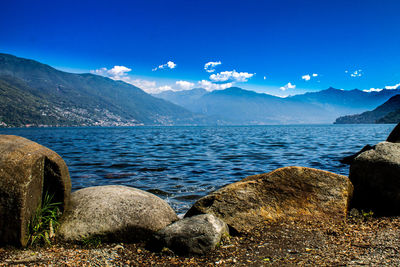 Scenic view of sea and mountains against blue sky