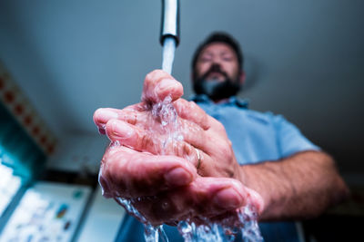 Low angle view of man washing hands at home