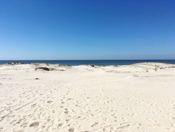 Scenic view of sandy beach against blue sky