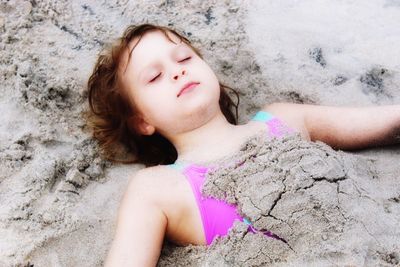 Girl buried in sand at beach