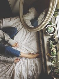 High angle view of girl sitting on bed