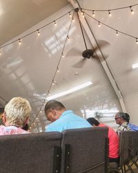 Rear view of people sitting on ceiling