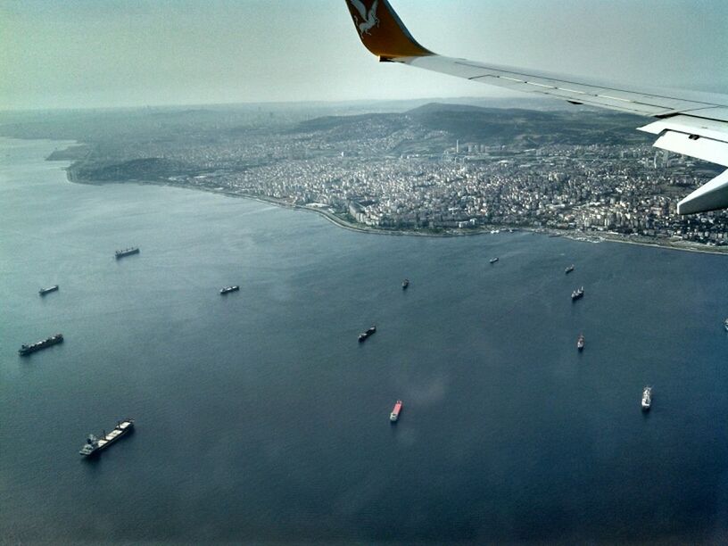 flying, airplane, air vehicle, transportation, aircraft wing, mode of transport, mid-air, aerial view, part of, cropped, travel, journey, on the move, aeroplane, public transportation, airplane wing, sea, landscape, aircraft, sky