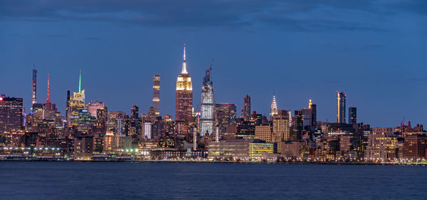 Illuminated buildings in city against sky