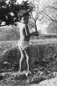 Rear view of shirtless girl standing outdoors