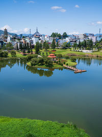 Scenic view of lake by buildings against sky