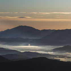 Scenic view of silhouette mountains against sky during sunset