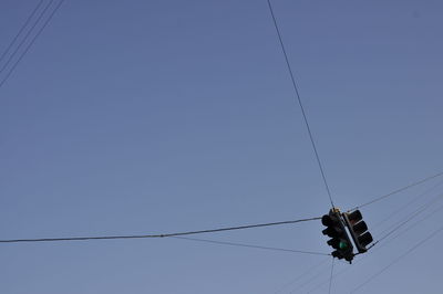 Low angle view of overhead cable car against clear blue sky