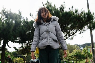 Woman standing in park against sky