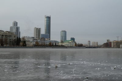 Buildings in city against sky during winter