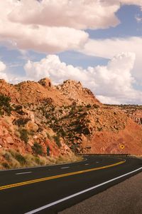 Road by mountain against sky