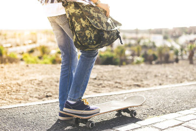 Low section of person standing on skateboard outdoors