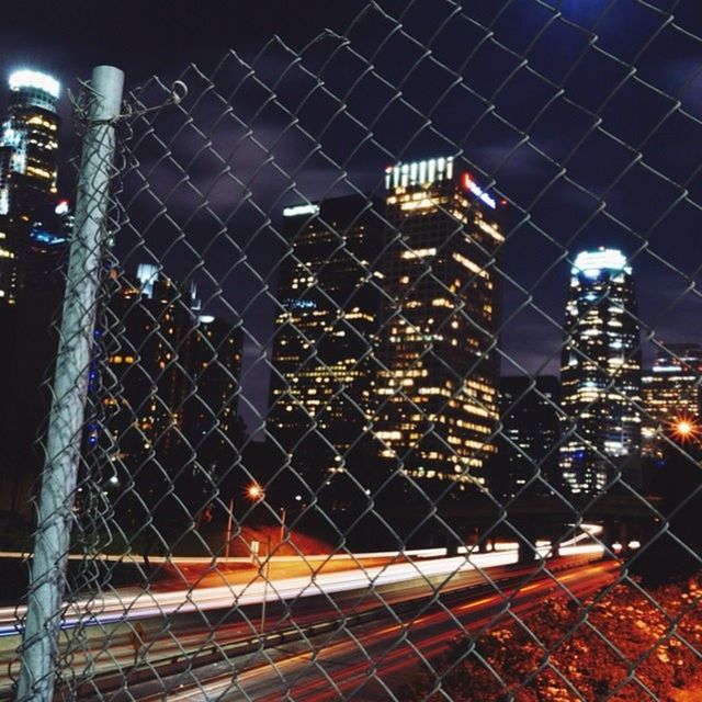 illuminated, night, architecture, built structure, metal, building exterior, city, lighting equipment, chainlink fence, sky, pattern, safety, indoors, no people, protection, modern, fence, metallic, security