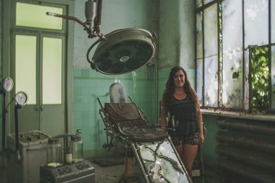 Portrait of woman standing at abandoned building