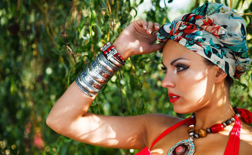 Portrait of young woman wearing headscarf while standing near tree