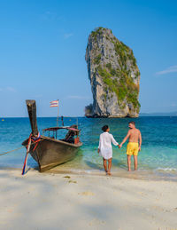 Rear view of woman standing at beach