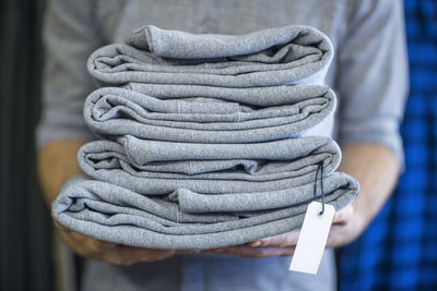 Man holding stack of folded clothes