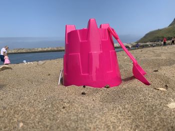 Red umbrella on beach against sky