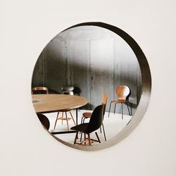 Empty chairs and table in cafe against wall