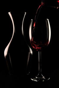 Close-up of wine glass on table against black background