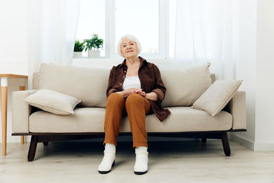 Young woman sitting on sofa at home