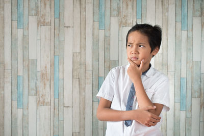 Thoughtful boy against wall