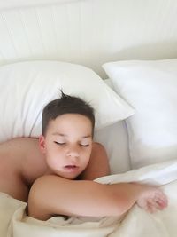 Cute boy sleeping on bed at home