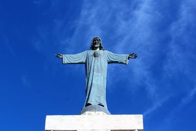 Low angle view of statue against blue sky