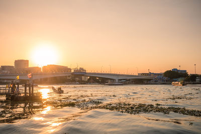 Bridge over river against sky during sunset