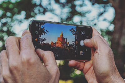 Midsection of person photographing with mobile phone san luca bologna