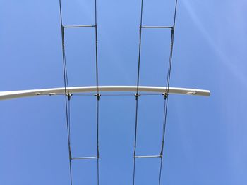 Low angle view of power lines against clear blue sky