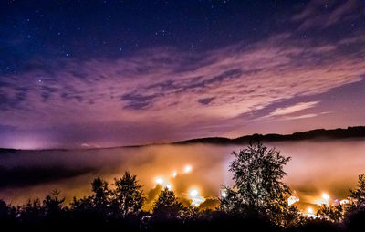 Silhouette trees against sky at night