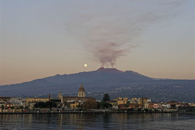 Panorama of the city of riposto with the background of etna and the moon