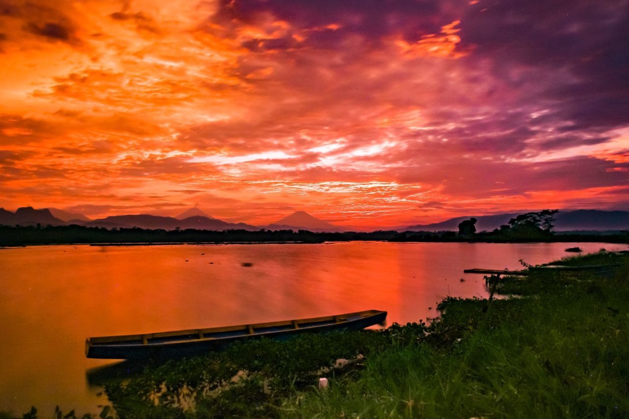 sunset, orange color, scenics, tranquil scene, water, lake, beauty in nature, tranquility, cloud - sky, dramatic sky, vibrant color, sky, idyllic, non-urban scene, romantic sky, mountain, majestic, nature, cloud, tourism, outdoors, red, atmosphere, vacations, summer, rural scene, cloudscape