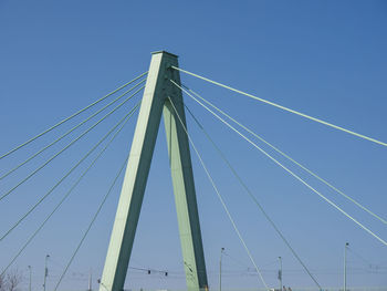 Low angle view of suspension bridge against clear blue sky