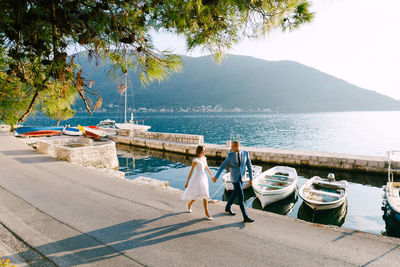 Rear view of people on shore against sky