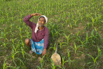Full length portrait of a smiling young man in field