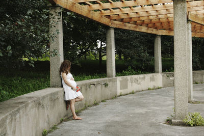 Full length of woman standing by tree