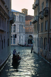 Venice, italy water canal, italian man with the gondola is rowing on a narrow canal with tourists