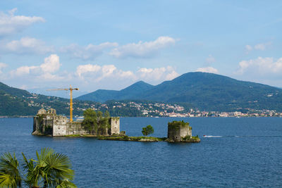 Scenic view of sea by buildings against sky