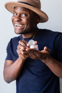 Midsection of man wearing hat against white background