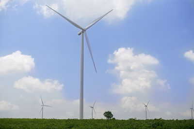 Low angle view of windmill on field against sky