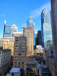 Buildings in city against blue sky