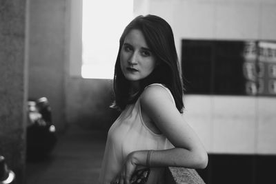 Thoughtful woman looking away while standing by railing