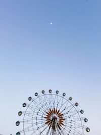 Low angle view of ferris wheel against clear blue sky