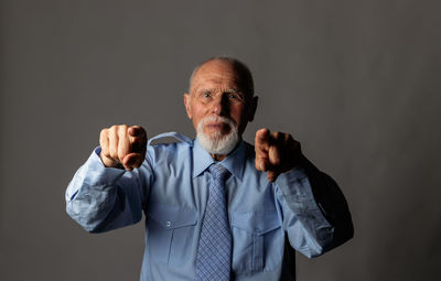 Portrait of man standing against black background